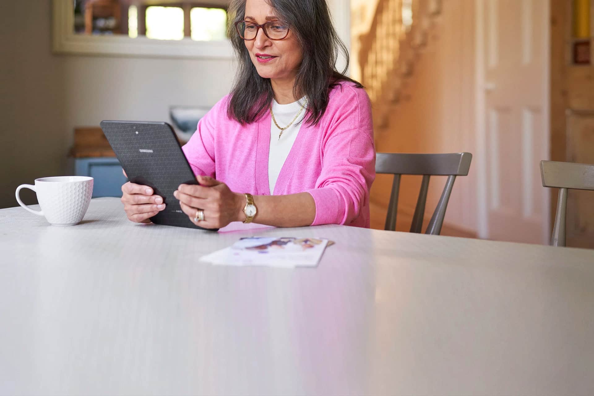 Photo of a woman at home using her tablet.