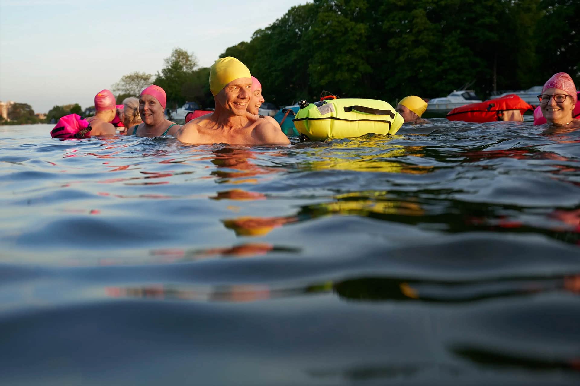 A group of swimmers in the water wearing colourful swimming caps.